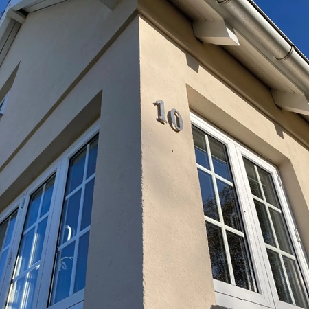 Moderne hus med store vinduer, malet med KEIM Granital silikatmaling i lys beige farve